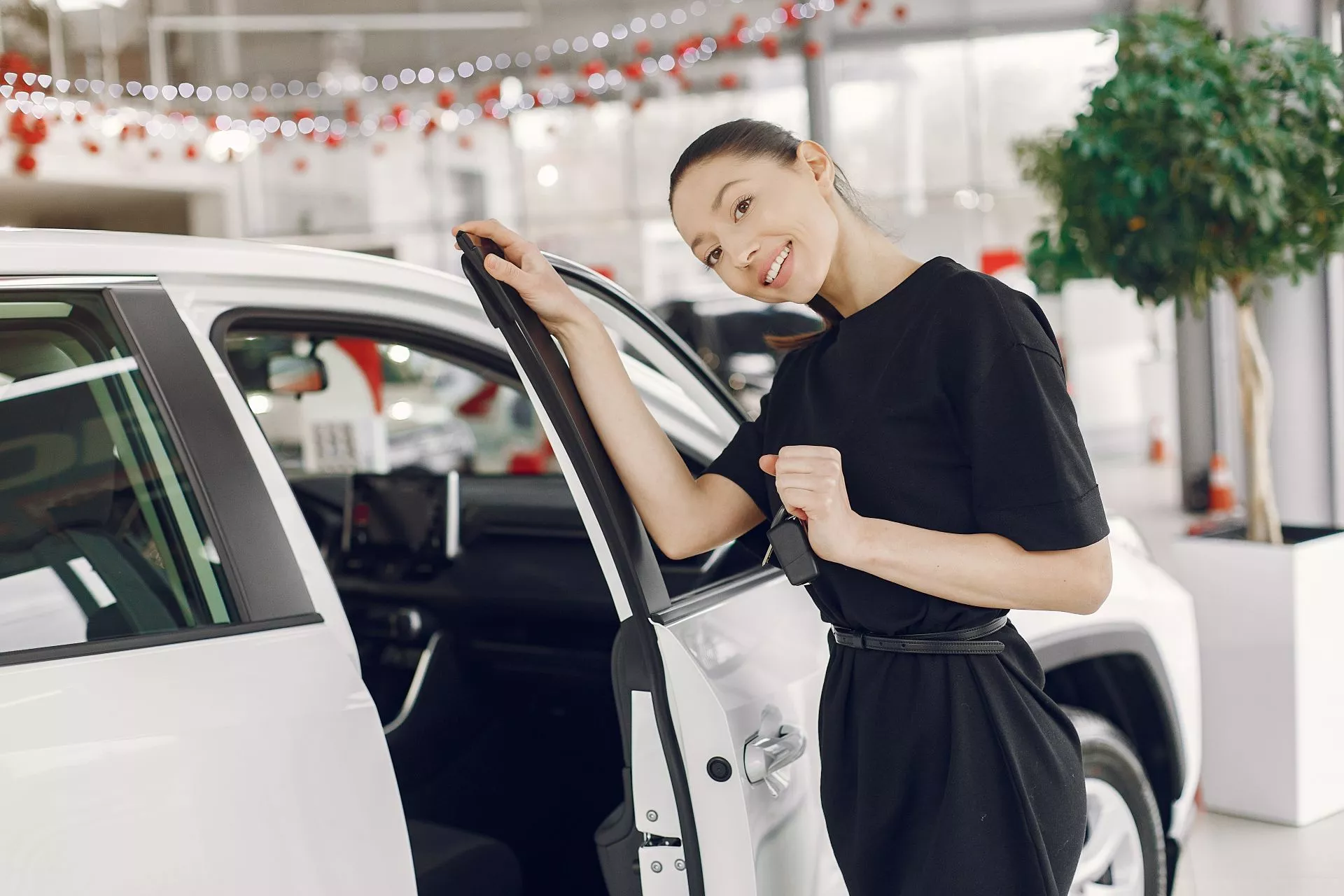 汽車展示間內一對男女正在檢視藍色休旅車尾燈與車況，呈現購車評估與車輛細節檢查情境，象徵汽車價值判斷與借款評估參考畫面