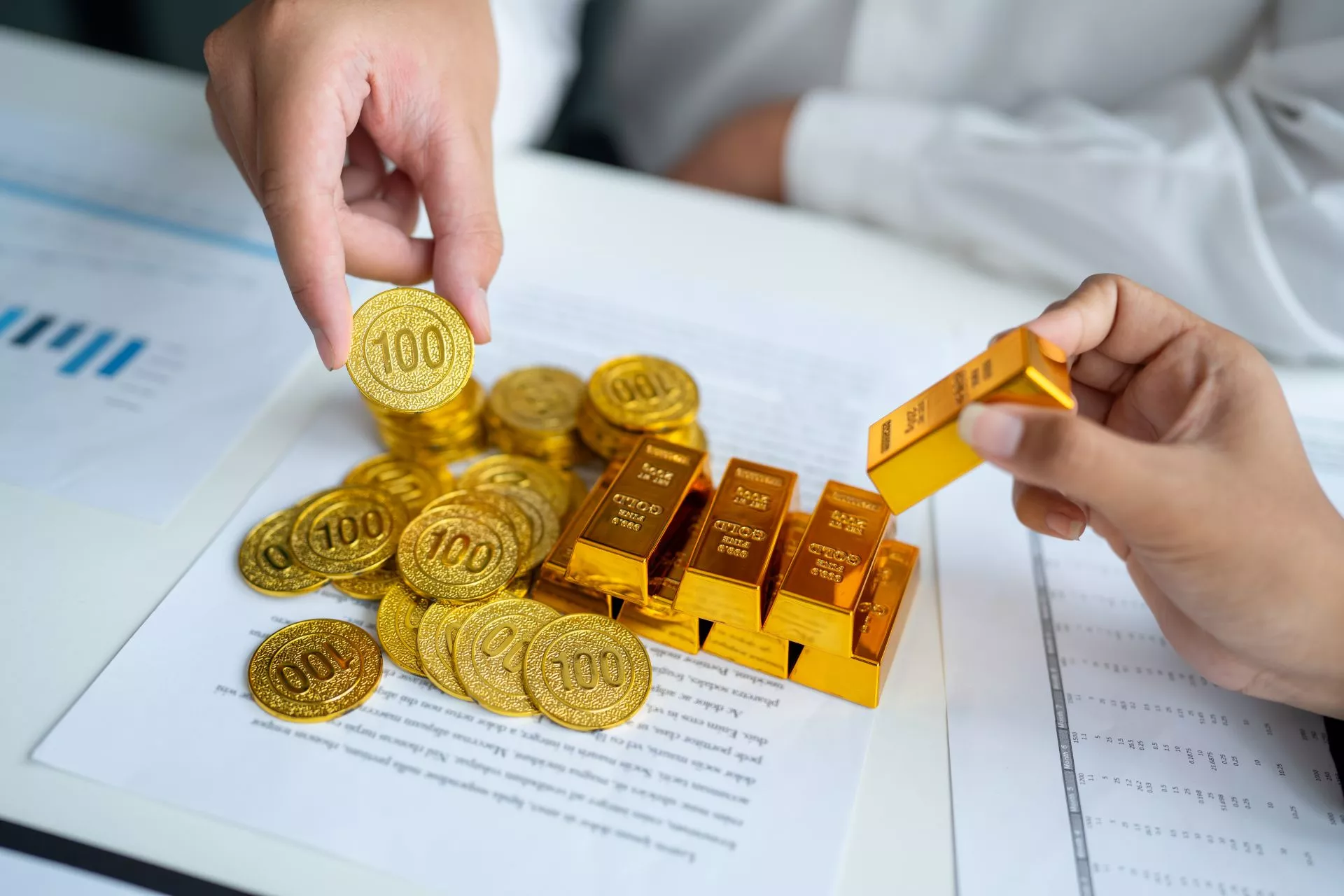 雙手正在檢視金條與金幣，呈現台中黃金典當、黃金估價、金價波動、重量成色確認與當鋪借款週轉情境。